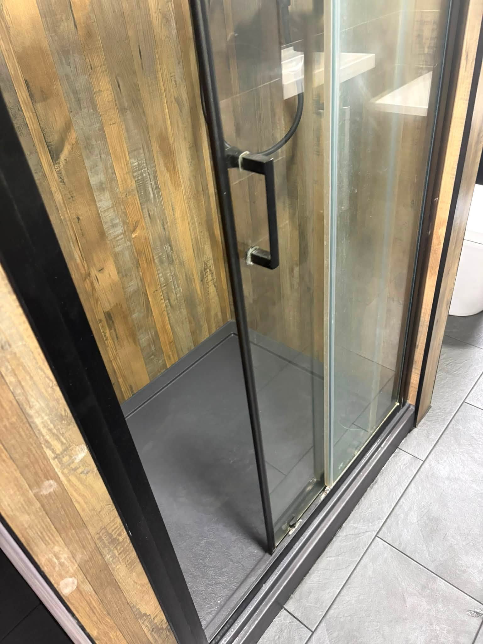 Walk-in shower enclosure with wood-effect tiling by Contrast Carpentry Ltd