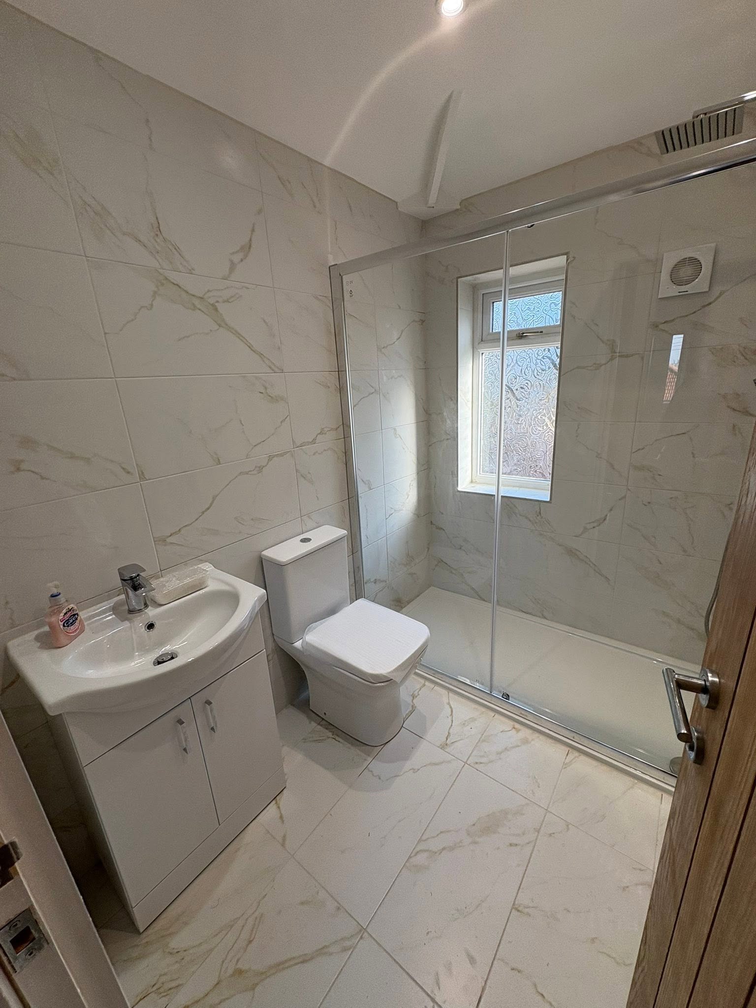 Marble-tiled bathroom with walk-in shower